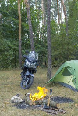 Bir çadır ve bir motosiklet ile ormanda kamp.