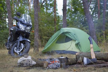 Bir çadır ve bir motosiklet ile ormanda kamp.