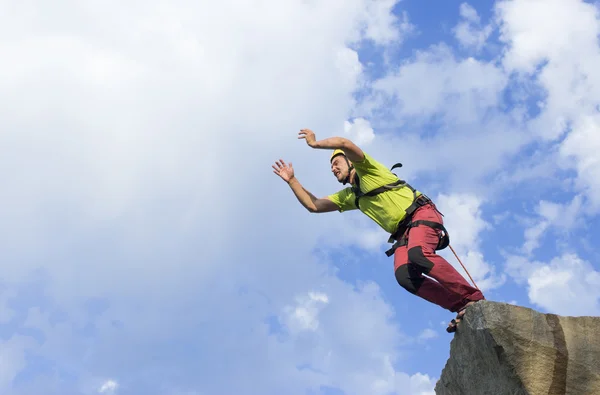 Saltar la cuerda de una roca alta en las montañas . — Foto de Stock