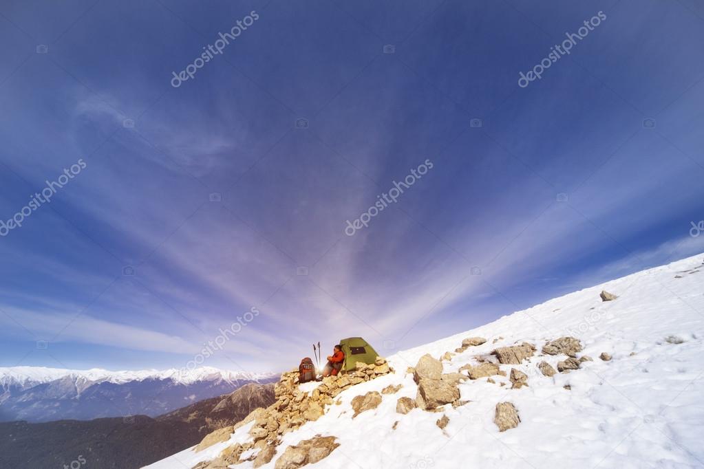 Winter camping in the mountains with a backpack and tent.