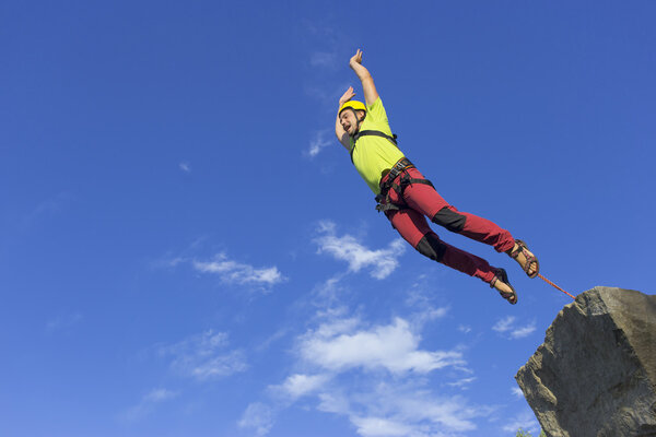 Перейти веревку с высокой скалы в горах
. 