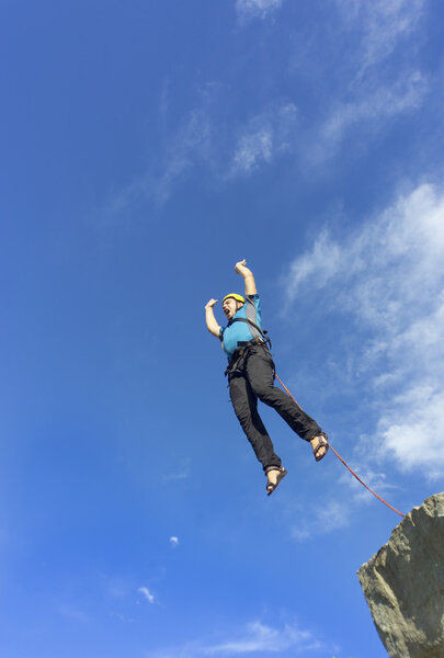 Перейти веревку с высокой скалы в горах
. 