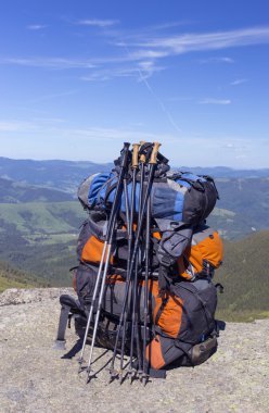Mavi gökyüzüne karşı dağlarda sırt çantaları ile kamp.