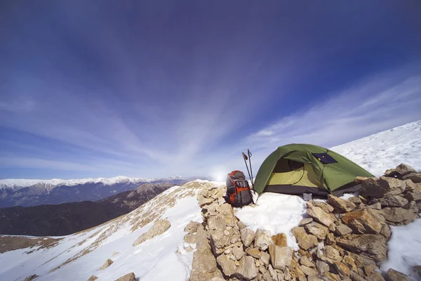 Acampamento de inverno nas montanhas com uma mochila e tenda . — Fotografia de Stock