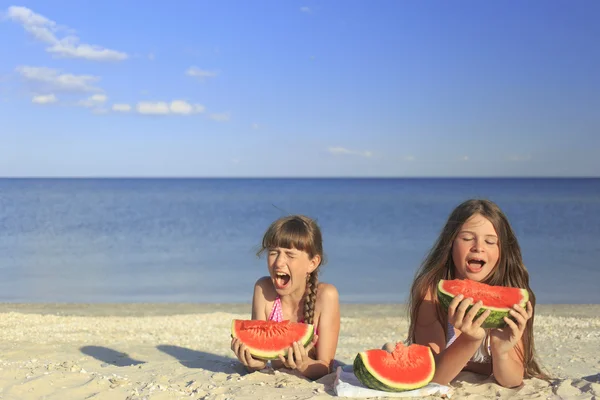 Happy children on the beach eating sweet watermelon. — Stock Photo, Image