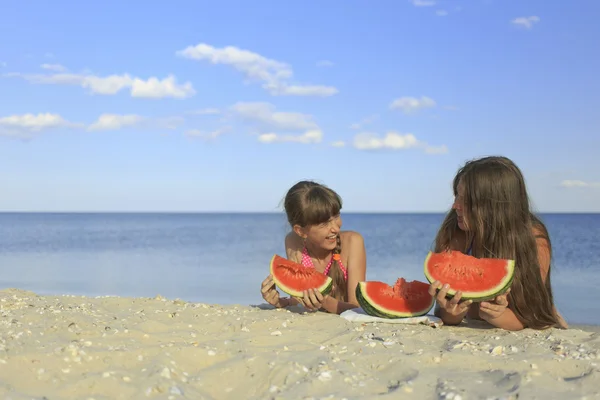 Happy children on the beach eating sweet watermelon. — Stock Photo, Image