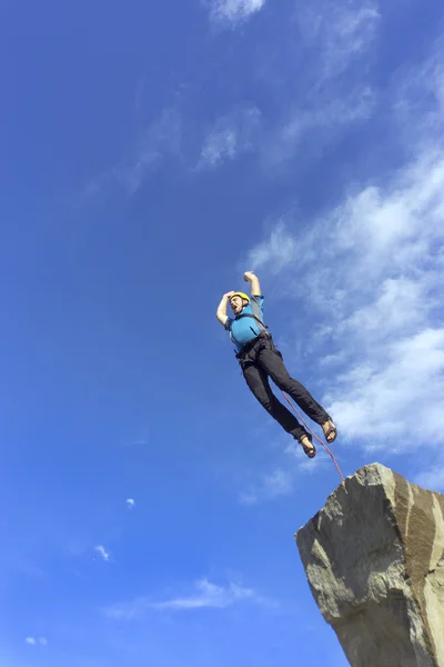 Saltar la cuerda de una roca alta en las montañas . — Foto de Stock