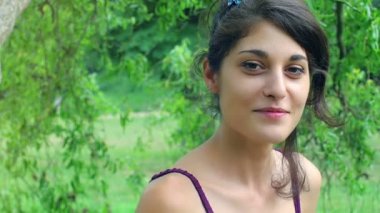 Gülümseyen kadın doğada elini sallıyor.