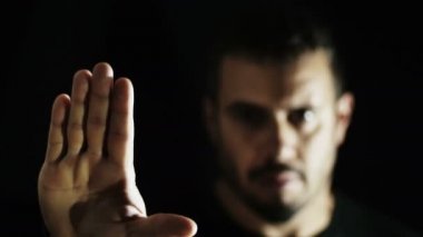 siyah arka plan üzerine izole adam birisi ya da bir şey durdurmak için bir jest yapar