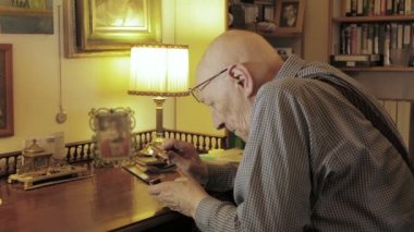 Son sınıf öğrencisi cep telefonu ekranını büyüteçle görmeye çalışıyor.