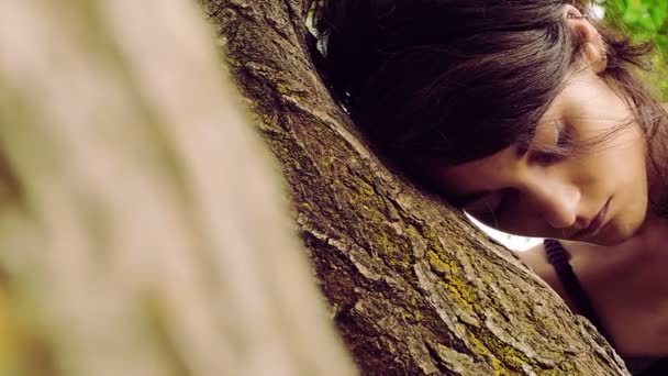 Bouleversé et déprimé jeune fille debout contre un arbre : séquences 4k — Video