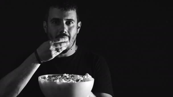 Adicto y solitario hombre está comiendo pop-corn en la oscuridad — Vídeo de stock