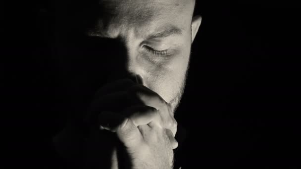 Молодой человек глубоко в молитве — стоковое видео