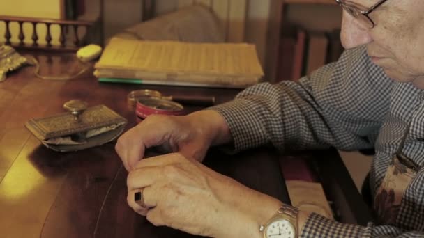 Elderly Man Using Magnifying Glass Little Pieces Desk — Stock Video