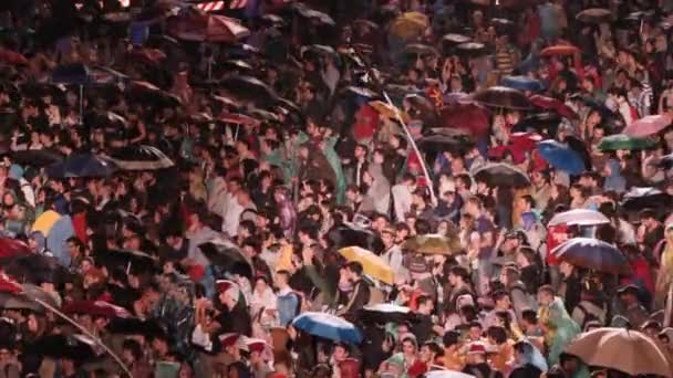Rom, Italien, maj 1, 2015-människor tittar på en konsert under regn framför scenen: Rom, 1 maj — Stockvideo