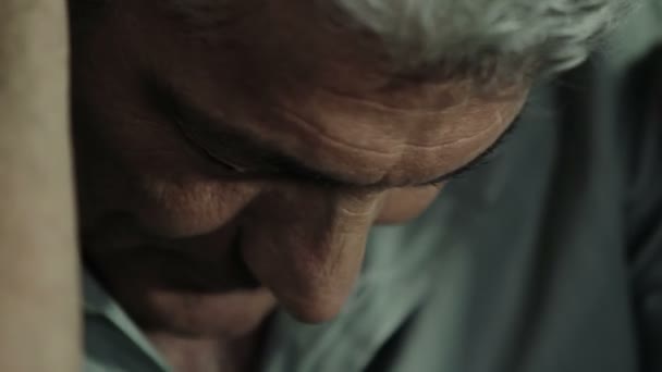 Hombre deprimido perturbado sentado en el suelo y sosteniendo su cabeza entre las manos — Vídeo de stock