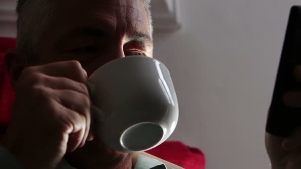 Mannen dricker rykande drycken i hälften ljus: kaffe, te, varm, kopp, mugg, koppla av — Stockvideo