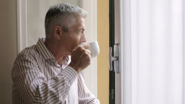 Cher homme buvant du thé chaud à la fenêtre : café, boisson, vapeur, regarder — Video