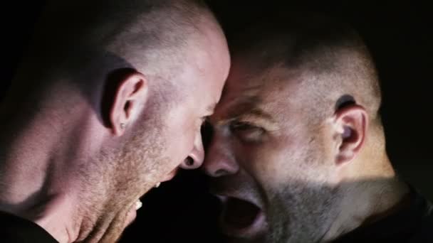 Dos tíos gritándose el uno al otro y van a golpear en la oscuridad — Vídeos de Stock