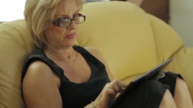 Olgun kadın evde tablet bilgisayar kullanma