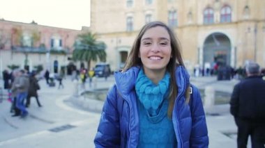 Güzel ince kız yürüyüş aşağı belgili tanımlık sokak ve gülümsüyor. Steadycam