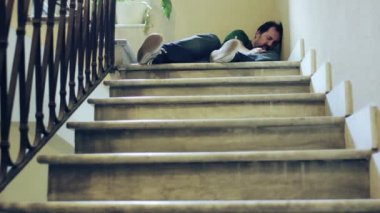 Sarhoş adam bir merdiven üzerinde uyuyor