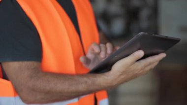 Warehouseman koruyucu yelek ve tablet ile