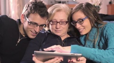 Mutlu aile genç bir erkek kardeşi ve kız kardeşi ve anneleri ile bir tablet PC'yi kullanma