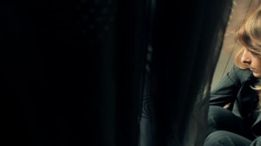 Pencere yakın katta oturan üzgün işkadını