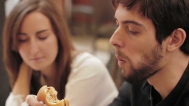 Mutlu kız ve hamburger yiyen biri