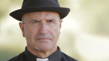 Rahip şapkalı kamera görünüyor