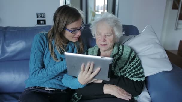 Young woman teaches her grandmother work with compute and teaching her to use it — Stock Video