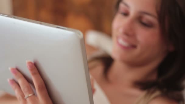 Женщина с планшетным компьютером в постели — стоковое видео