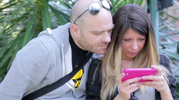 Homme et femme jouant ensemble jeu vidéo sur smartphone — Video
