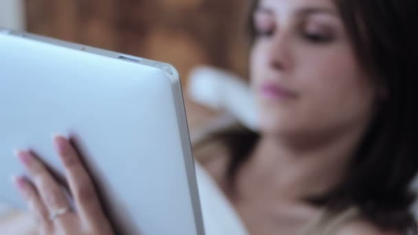 Woman using tablet computer in bed — Stock Video