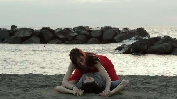 Et attraktivt par som kysser på stranden – stockvideo