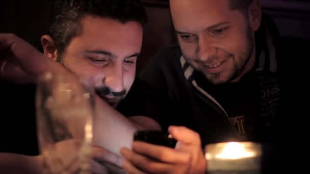 Två män med mobiltelefon i en pub — Stockvideo