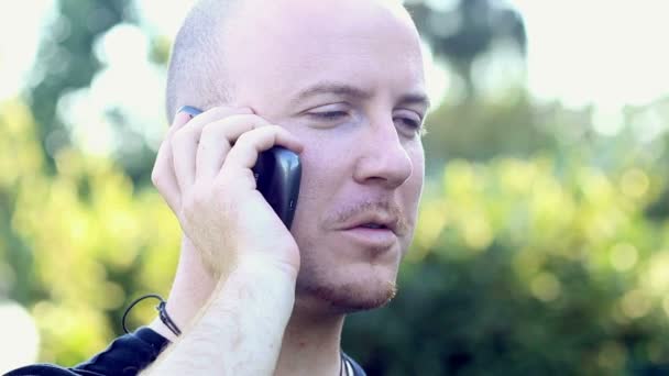 Молодой человек говорит по телефону — стоковое видео