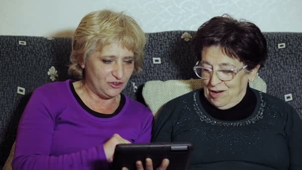 Donna adulta che dà a sua madre un tablet PC e le insegna a usarlo — Video Stock