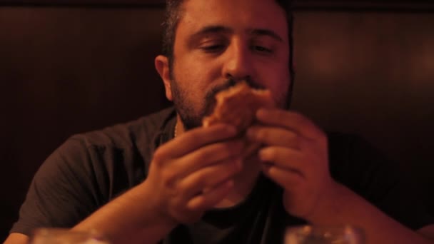 Guy mangiare hamburger in un pub — Video Stock