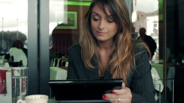 Üzletasszony olvasó egy cikk rajta tabletta számítógép. Egy kávézóban. — Stock videók