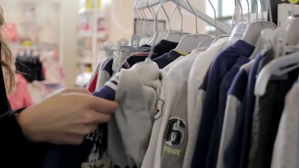 Attraktiv tjej söker kläder — Stockvideo