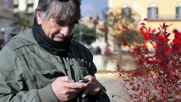 Man texting op smartphone winterkleren dragen — Stockvideo