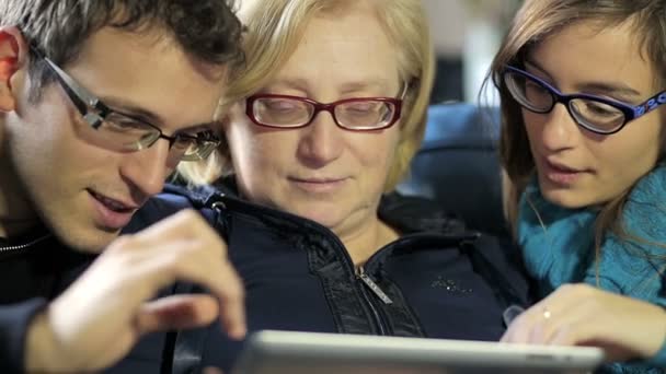 Retrato de uma mãe curiosa com os filhos. Eles usando tablet pc em casa — Vídeo de Stock