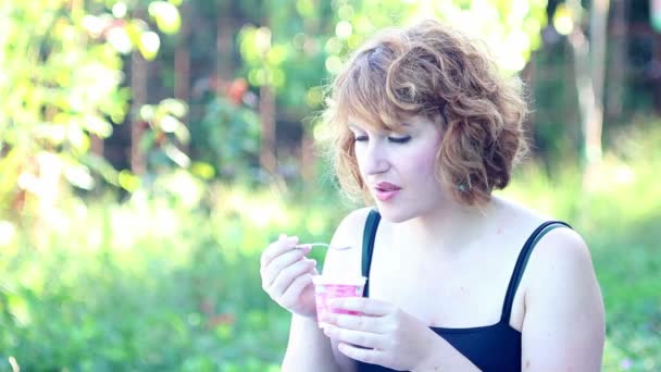 Молода жінка їсть йогурт — стокове відео