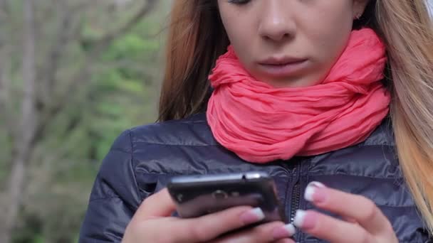Frau benutzt Handy im Park — Stockvideo