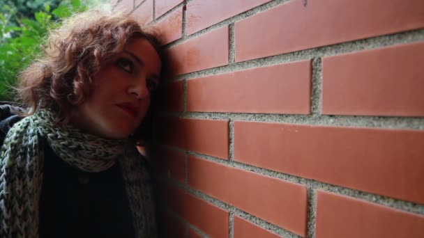Mujer triste junto a la pared — Vídeos de Stock