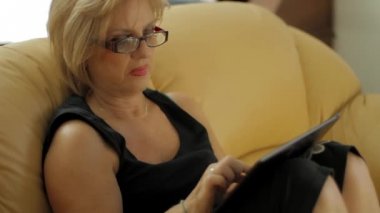 tablet bilgisayar kullanan üst düzey kadın