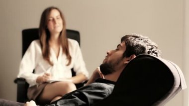 Genç adam bazı açıklayan onun psikiyatrist konuşurken bir kanepede uzanmış