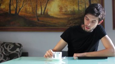Tablet - genç erkek düşüncelerinde bir sınav ve almak kahve yapıyor